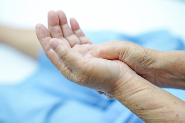 Азіатський старший або літні старі жінки пацієнт відчуває біль її руки на ліжку в палаті медсестринської лікарні: здорова сильна медична концепція. - Фото, зображення