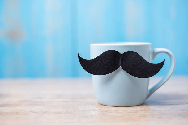 Blue coffee cup with Black mustache on wood table background in  - Fotoğraf, Görsel