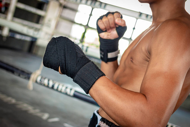 Hombre boxeador envolviendo su mano en el deporte arena de boxeo
. - Foto, Imagen
