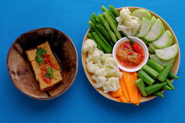 Κορυφαία θέα στο δίσκο φαγητό, βραστά λαχανικά, τόφου, ρύζι σε μπλε πίσω μέρος - Φωτογραφία, εικόνα