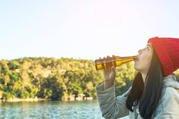 Γυναίκα κάθεται πίνοντας μπύρα χαλαρωτικό σε διακοπές με όμορφη n - Φωτογραφία, εικόνα