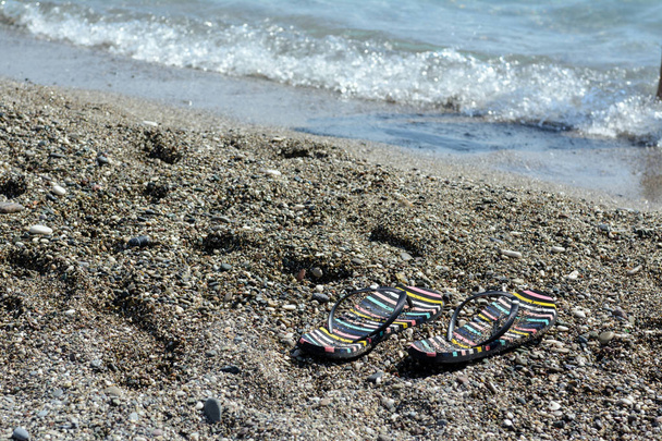 koziołki flop nad morzem na piasku, w pobliżu wody. Koncepcja-wakacje na plaży, wakacje nad morzem - Zdjęcie, obraz