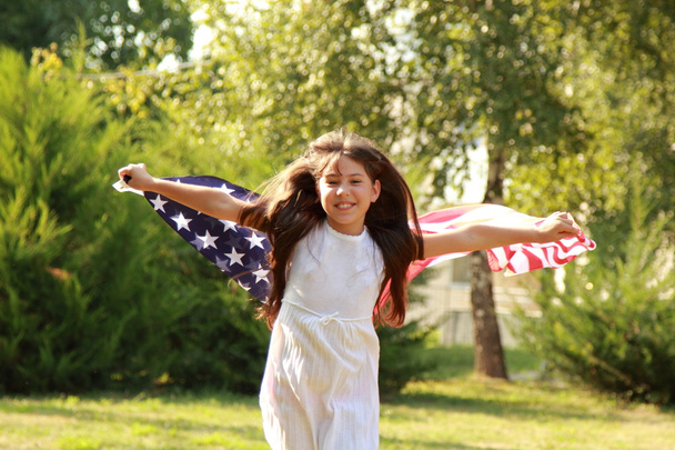 Girl holding a large American flag - Фото, зображення