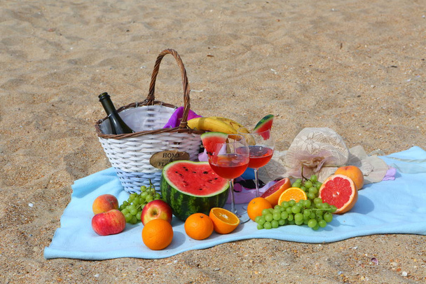 Beach picnic with red wine, watermelon and fruit - Foto, imagen