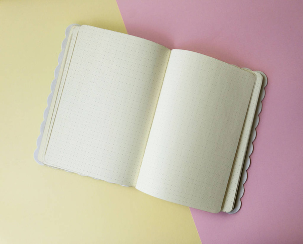 Tető kilátás-ból papír jegyzék és üres ágynemű-val pontok-ra könnyű rózsaszín sárga háttér. Üzleti vagy oktatási koncepció, másolási hely a szöveghez - Fotó, kép