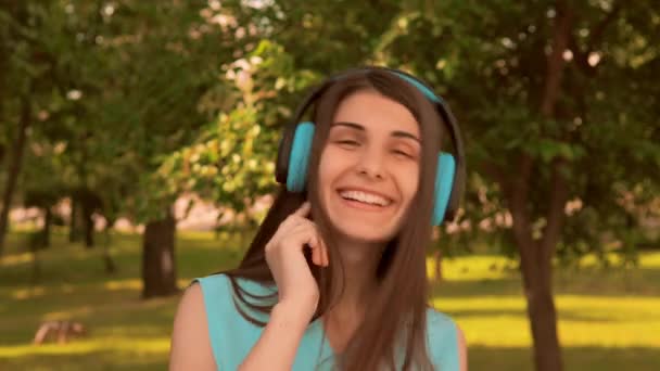 caucasian girl front view looking camera smiling using headphones - Filmagem, Vídeo