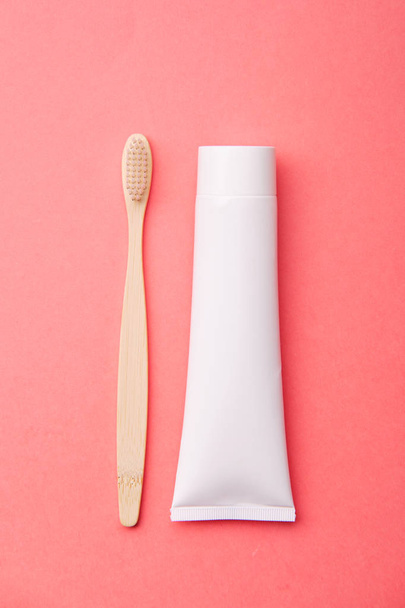 Wooden Toothbrush with Toothpaste on Pink Background  - Foto, Bild