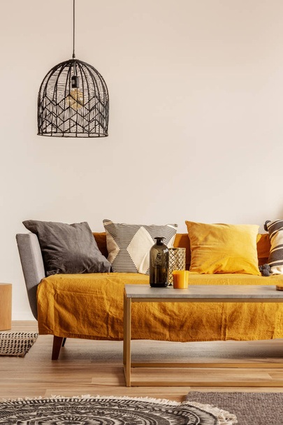 Copy space on empty white wall of fashionable living room interior with yellow and orange accents - Photo, image