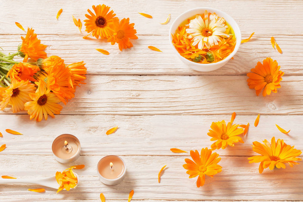  Medicinal flowers of calendula on white wooden background - Foto, afbeelding