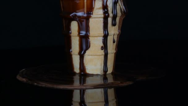 Tající zmrzlina, na které je na černém pozadí omáčka z čokoládového sirupu - Záběry, video