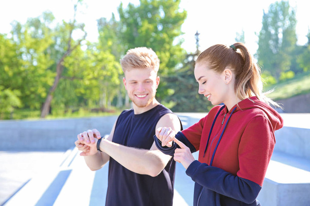 Jóvenes deportistas revisando su pulso al aire libre
 - Foto, Imagen