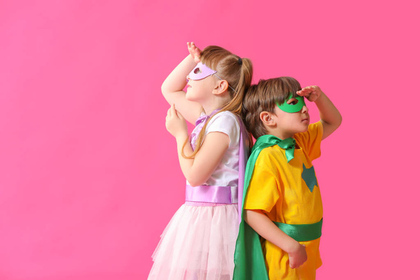 niedlichen kleinen Kindern als Superhelden auf farbigem Hintergrund gekleidet - Foto, Bild
