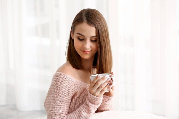 Kaunis nuori nainen juo teetä kotona - Valokuva, kuva