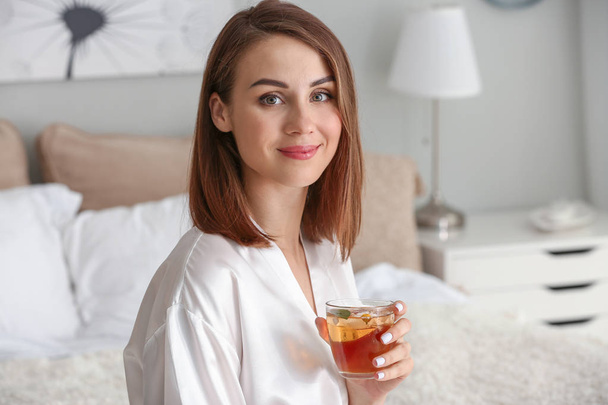 Schöne junge Frau trinkt Tee zu Hause - Foto, Bild