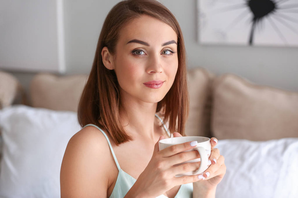 Beautiful young woman drinking tea at home - Foto, Bild