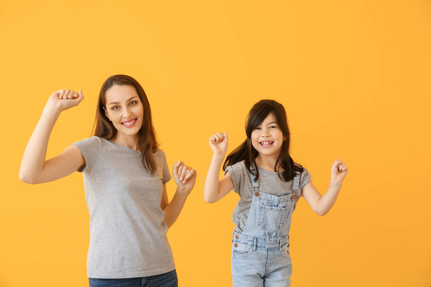 Portrait of dancing mother with daughter on color background - Photo, Image
