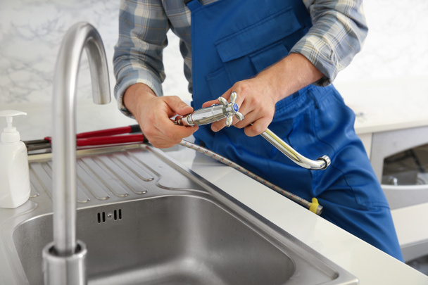 Plumber installing sink in kitchen - Zdjęcie, obraz