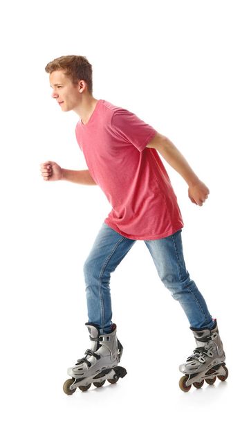 Teenage boy on roller skates against white background - Foto, afbeelding