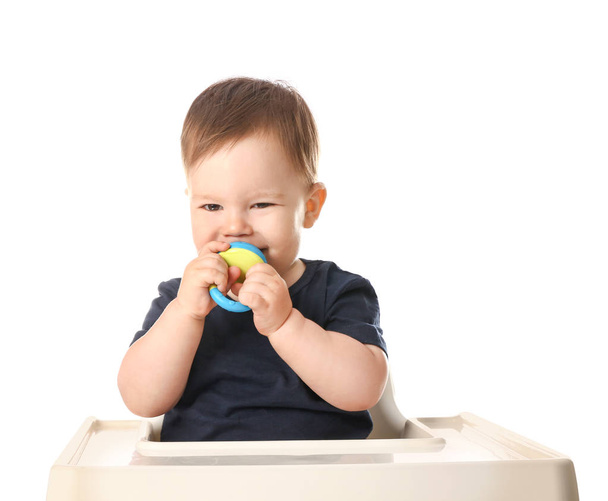 Cute little boy with nibbler sitting in high chair against white background - Foto, afbeelding