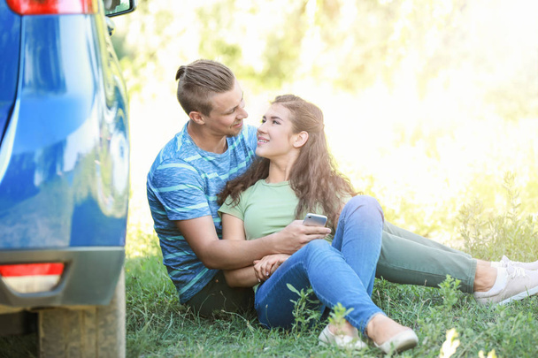 Happy young couple near car outdoors - Фото, изображение