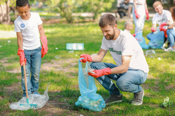 Волонтери збирають сміття в парку
 - Фото, зображення