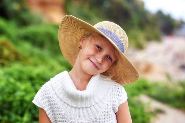 Πορτρέτο ενός μικρού κοριτσιού σε ένα πλατύ καπέλο σε εξωτερικούς χώρους - Φωτογραφία, εικόνα