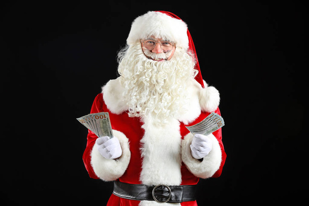 Święty Mikołaj z pieniędzmi na ciemnym tle - Zdjęcie, obraz