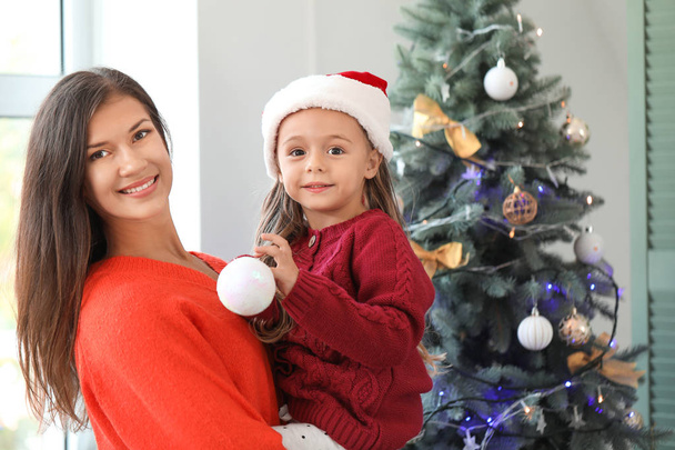 Woman and her little daughter at home on Christmas eve - Foto, Imagen