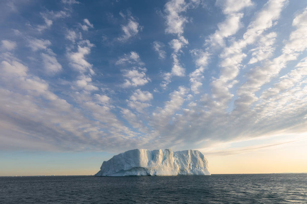 グリーンランドや南極の自然や風景。氷の間で船の旅。地球温暖化現象の研究異常な形と色の氷と氷山船に乗って美しい真夜中の太陽  - 写真・画像