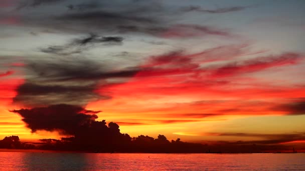 rode vlam zonsondergang op oranje hemel en donker rode wolk op de zee - Video