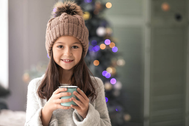 Little girl drinking hot chocolate at home on Christmas eve - Photo, Image