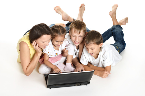 Family lying on a floor with laptop - Foto, afbeelding