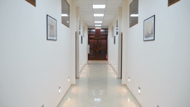 Перемещение через легкий коридор с множеством фотографий на стенах. Концепция отеля или офиса. Hd - Кадры, видео