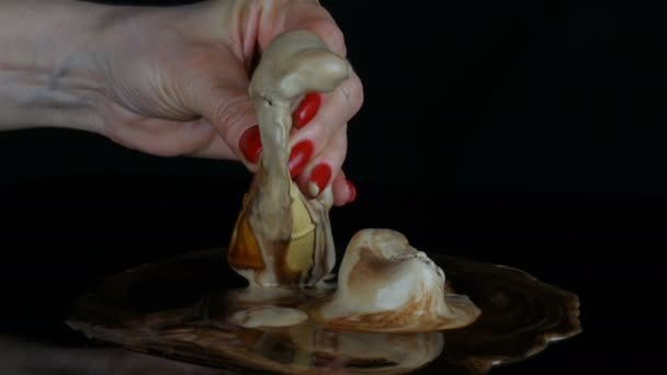Vrouwelijke hand met een rode manicure seksueel knijpt wafel beker met smeltend ijs - Video