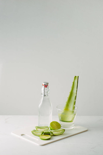 свіже листя алое вера і скляна пляшка на білому фоні
 - Фото, зображення
