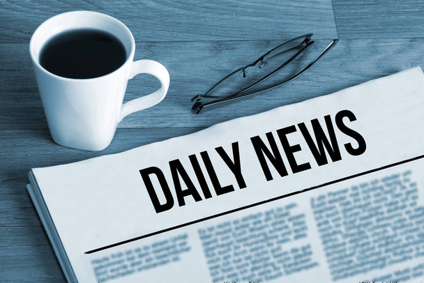 Una taza de café, vasos y periódico titulado Daily News
 - Foto, Imagen