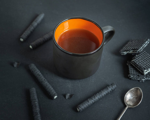 Snack dulce con tubos de café y waffle en colores negros
 - Foto, imagen
