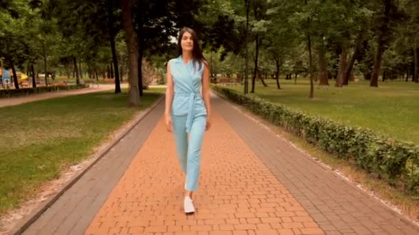 fiatal kaukázusi nő séta az utcán a városi parkban - Felvétel, videó