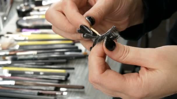 Мастер макияжа рук наносит специальный клей для склеивания длинных накладных ресниц в профессиональном салоне красоты
 - Кадры, видео