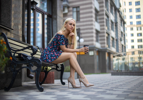 Girl with perfect legs posing in the city square. - Fotó, kép