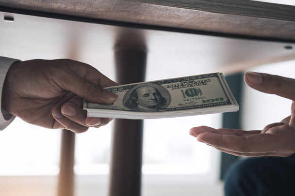 Podnikatelé dostávají peníze pod stůl, který je úplatek - Fotografie, Obrázek