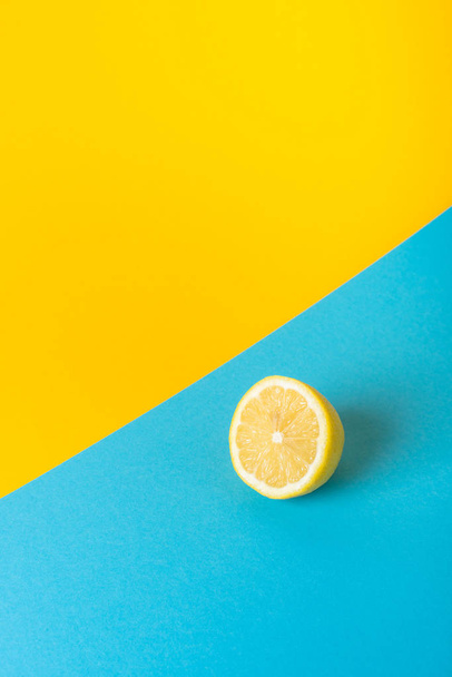 Přírodní čerstvé šťavnaté citrony na žlutém a modrém pozadí - Fotografie, Obrázek