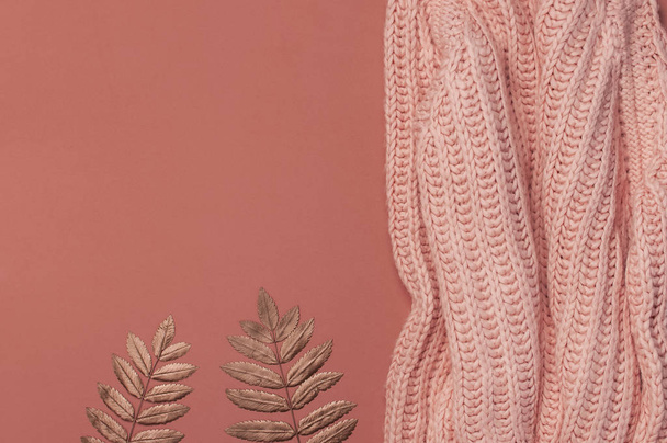 Flat lay autumn composition. Knitted woolen pink female sweater or plaid, golden dry leaves on burgundy brown background top view copy space. Fall concept. Fashion color, cozy autumn thing, clothes - Foto, Imagem