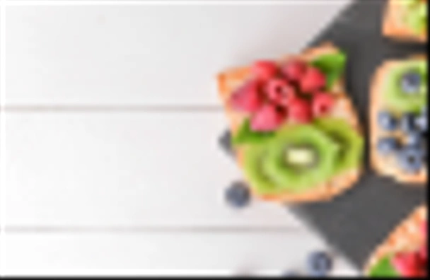Сланцева тарілка зі смачними бутербродами, ківі та ягодами на білому столі
 - Фото, зображення