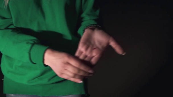 A zöld pulóveres lány karcos kezet mutat. A hölgy megsérült. Este a szabadban tölteni az időt - Felvétel, videó