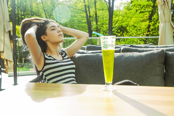 young girl drinking green cocktail smoothie  with a straw. - 写真・画像