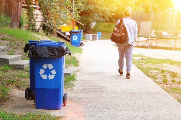 Έννοια της ανακύκλωσης αποβλήτων. Μπλε δοχεία για περαιτέρω επεξεργασία των απορριμμάτων. Συλλογή σκουπιδιών, πινακίδα οικολογίας. Ηλιοφάνεια. - Φωτογραφία, εικόνα