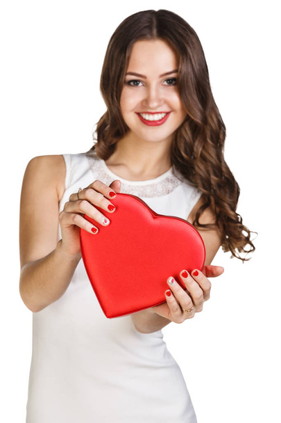 Young woman in white dress holds heart shaped box. - Photo, Image