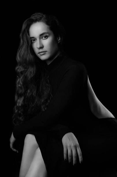 Portrait of a beautiful young woman with elegant long red shiny hair , hairstyle.In black elegant dress.Black and white. - 写真・画像