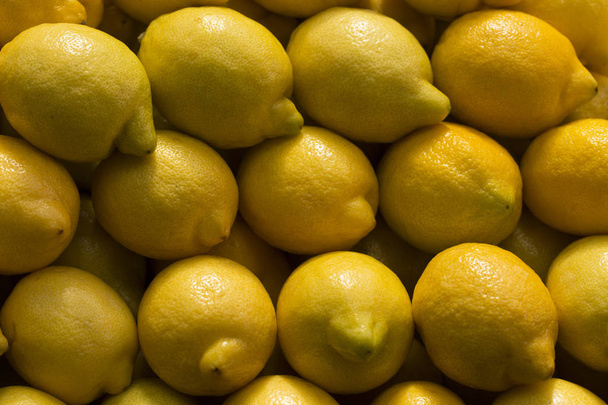 A pile of lemons at the vegetable market. Macro background of citruses. - Foto, imagen